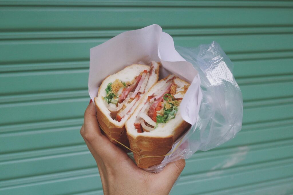 Vietnamese street food banh mi sandwich with pork, pickled vegetables, and cilantro.