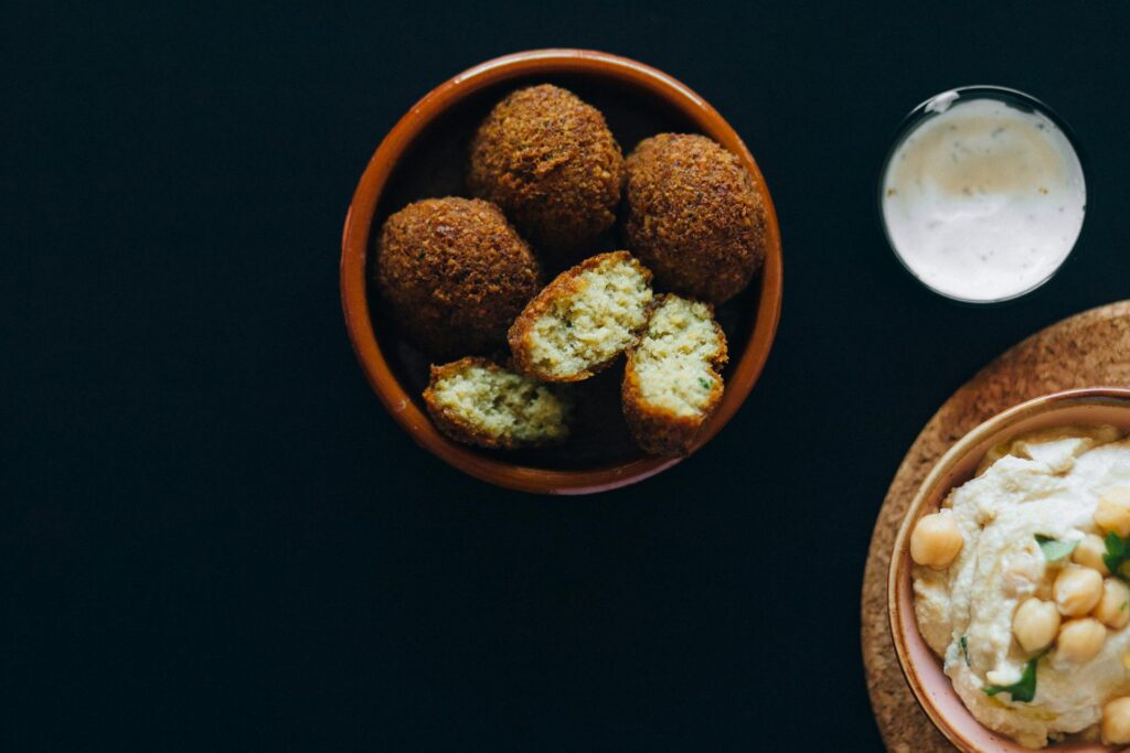 Middle Eastern falafel served in a pita with fresh vegetables and tahini sauce.