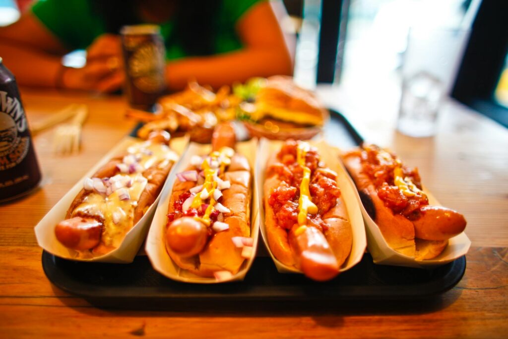 An American street food hot dog topped with mustard, relish, and onions.