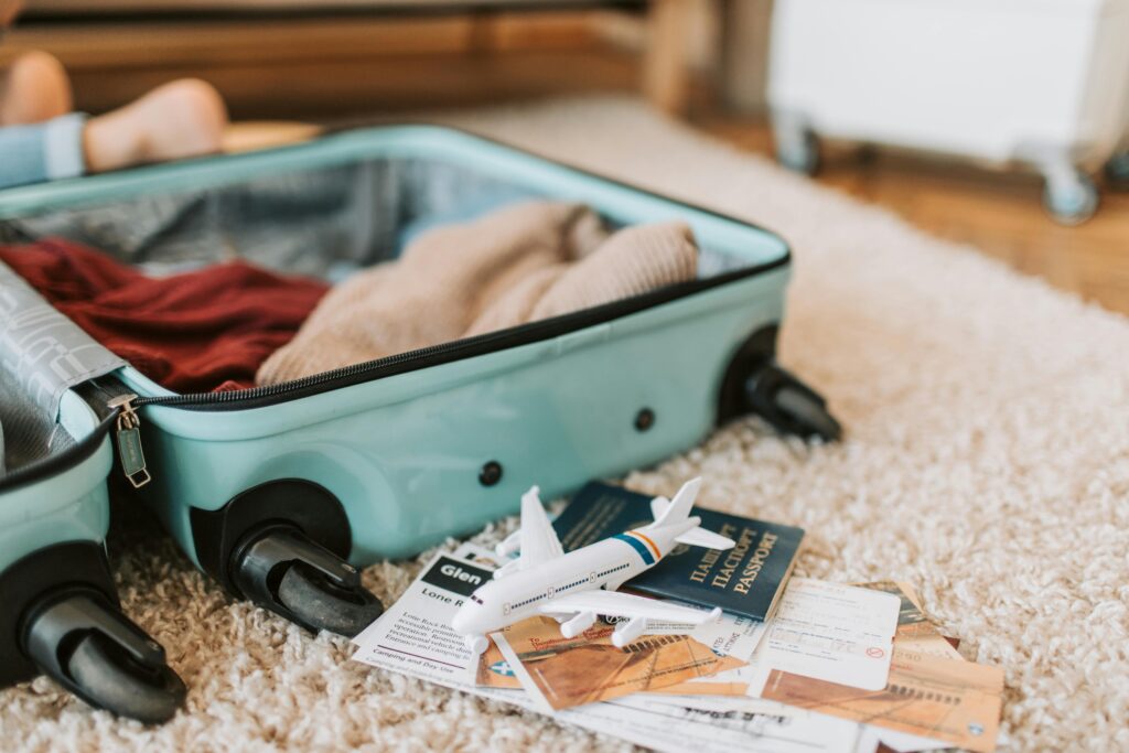 Open suitcase with clothes, passport, and boarding passes ready for travel.